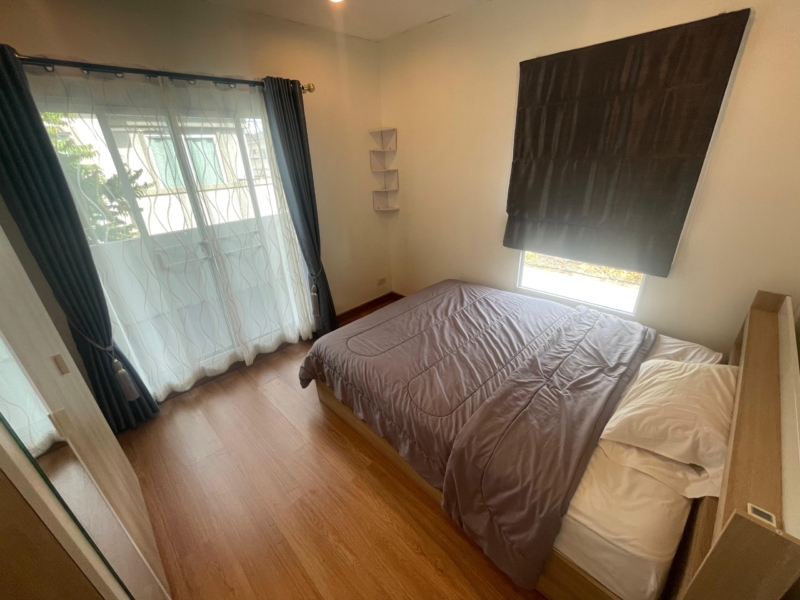 Spacious bedroom in a Thalang house for rent with wooden floor and large windows.
